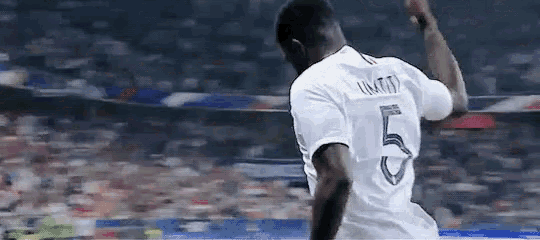 a soccer player wearing a white jersey with the number 5 on the back