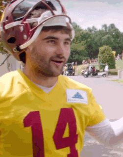 a football player wearing a yellow jersey with the number 14 on it