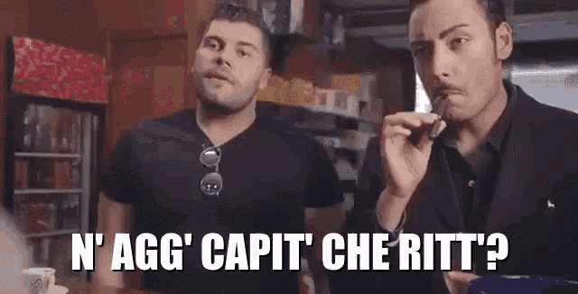 two men standing next to each other with the words n ' agg ' capit ' che ritt ' written on the bottom