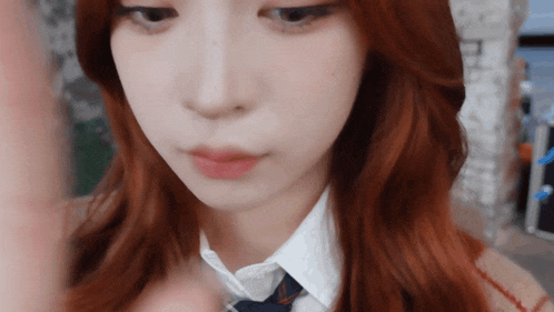 a close up of a girl 's face with red hair