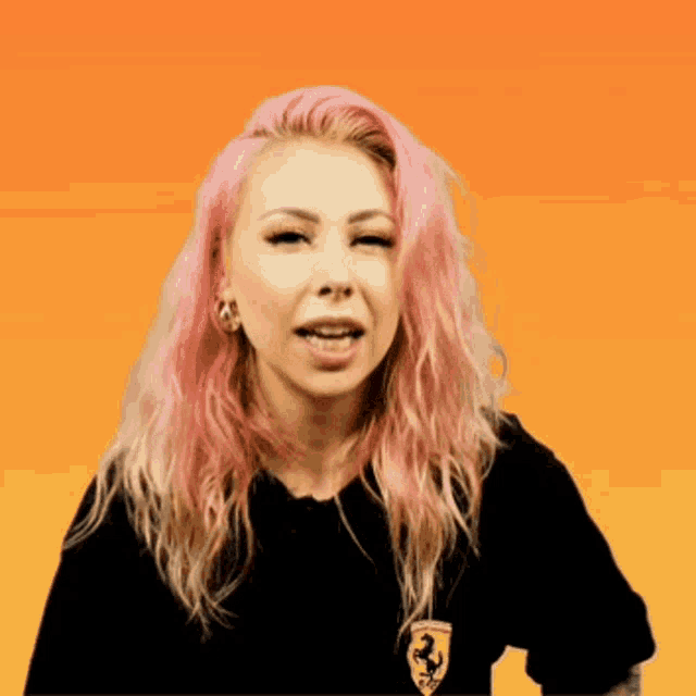 a woman with pink hair is wearing a black shirt with a ferrari logo