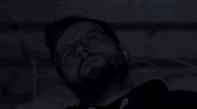 a man with glasses and a beard is laying down