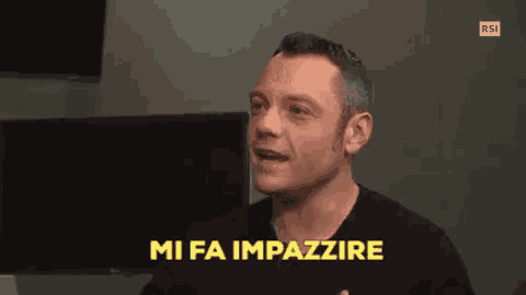 a man in a black shirt is making a funny face and says `` mi fa impazzire '' in yellow letters .