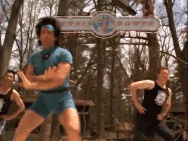 a man in blue shorts is dancing in front of a sign that says this power