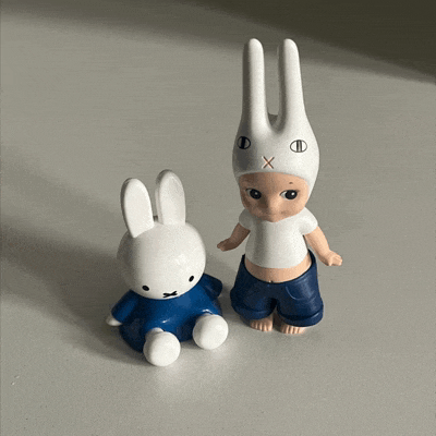 a white bunny figurine is next to a blue bunny