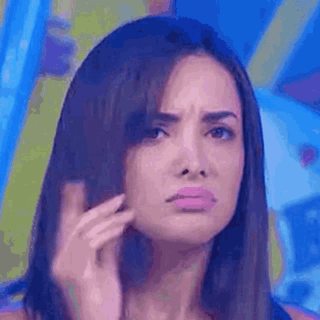 a close up of a woman making a funny face while touching her hair .