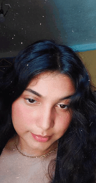 a girl with long black hair and a gold chain around her neck