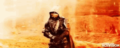 a man in a hooded jacket is standing in the desert holding a gun and a sword .