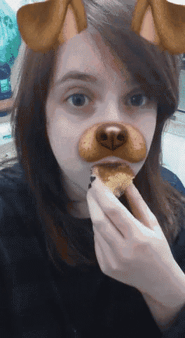 a girl with a dog mask on her face is eating something