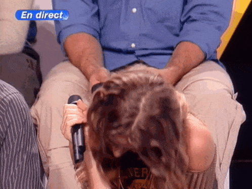 a woman is holding a microphone in front of a man with the words en direct on the bottom