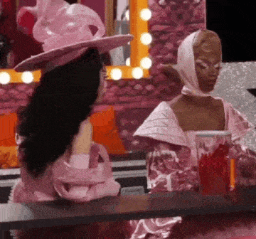 a woman in a pink dress is sitting next to another woman in a pink dress .