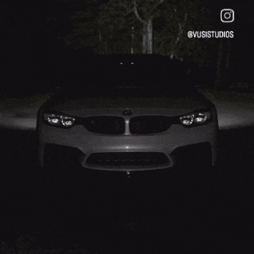 a car is driving down a road with a bright light coming out of its headlights .