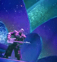 a statue of a man holding a sword is standing in front of a blue and purple background .