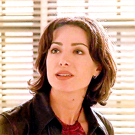 a close up of a woman 's face in front of a window with blinds