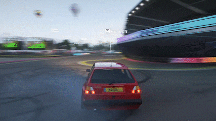 a red car is driving down a race track with a sign in the background that says ' driving elite '