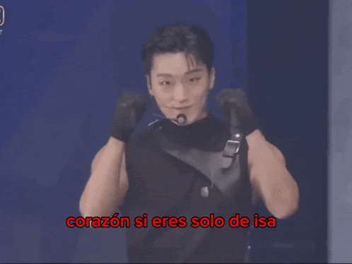 a man stands in front of a microphone with the words " corazon si eres solo de isa " below him