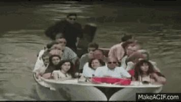 a large group of people are riding in a boat on a river .