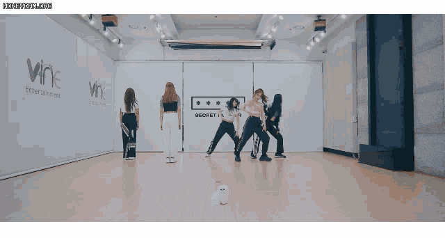 a group of women are dancing in a room that says wne entertainment on the wall