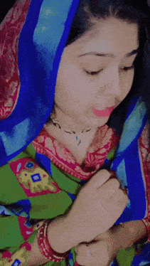 a woman wearing a blue scarf and a green dress