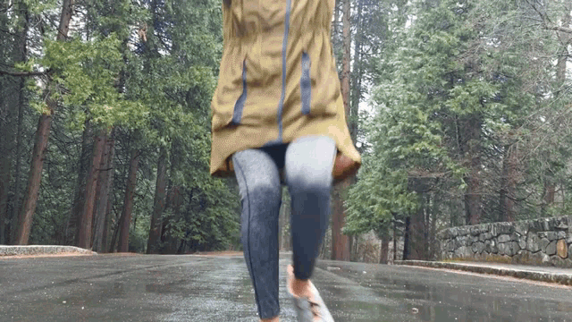 a person in a yellow jacket is running down a road
