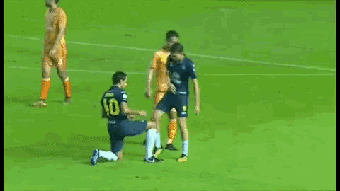 a soccer player with the number 10 on his jersey is kneeling on the field