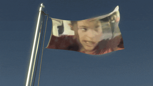 a flag with a picture of a boy on it is waving in the wind