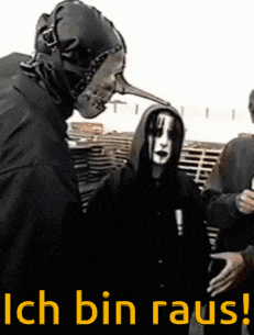 a man in a mask is shaking hands with another man in a black hoodie .