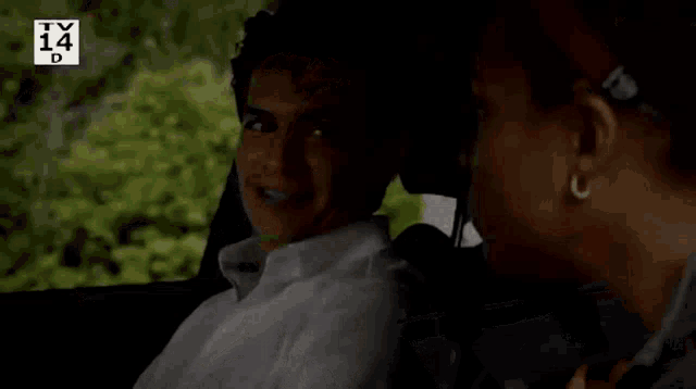 a man and a woman are sitting in a car and the man is smiling at the woman .