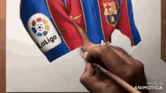 a person is drawing a soccer jersey with the laliga logo on it