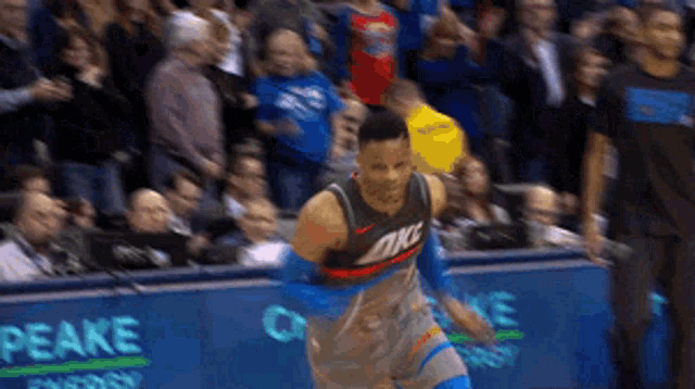 a basketball player wearing an okc jersey is running towards the crowd