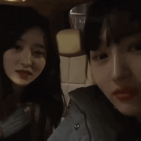two girls are sitting next to each other in a car .