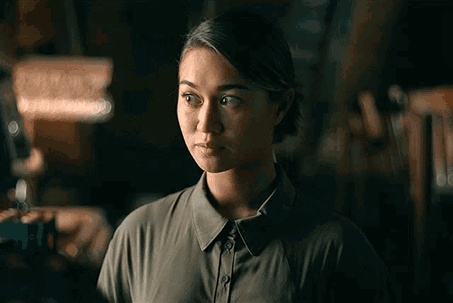 a woman in a green shirt looks to the side