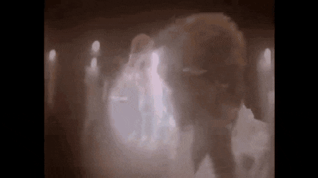 a person is standing in a dark room with smoke coming out of the ceiling .