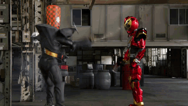 a man in a red and black costume is standing next to a man in a black and gold costume
