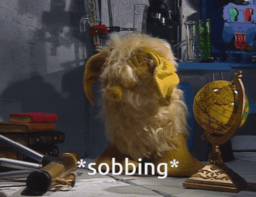 a stuffed animal is sitting on a table with the word sobbing written on the bottom