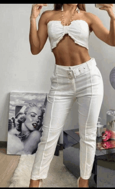 a woman taking a selfie in front of a marilyn monroe painting