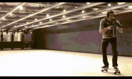 a man wearing headphones is riding a skateboard in a subway station .