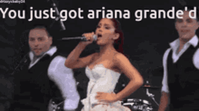 a woman singing into a microphone with the words " you just got ariana grande 'd " behind her