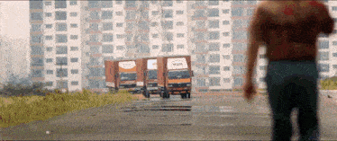 a man walking in front of a row of trucks one of which says mdh
