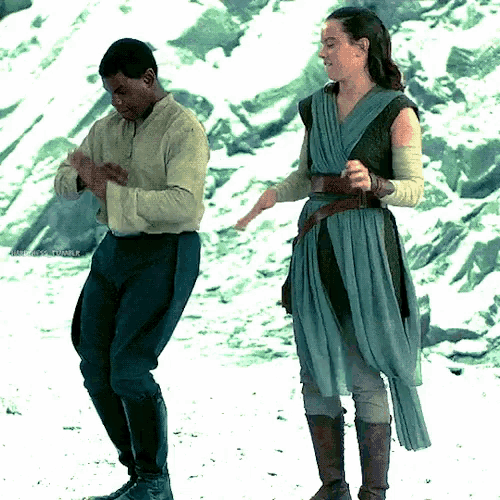 a man and a woman are dancing in the snow while standing next to each other .