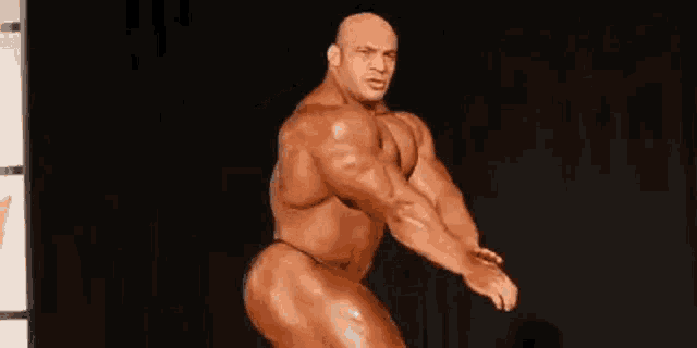 a bodybuilder is flexing his muscles on a stage .