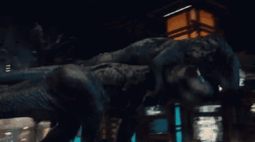 two dinosaurs are fighting in front of a building