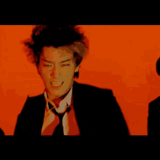 a man in a suit and tie with a red background