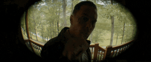 a man is standing on a balcony looking at something
