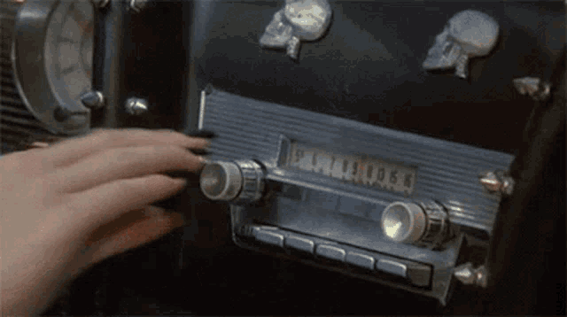 a person is adjusting a radio with a skull on the side
