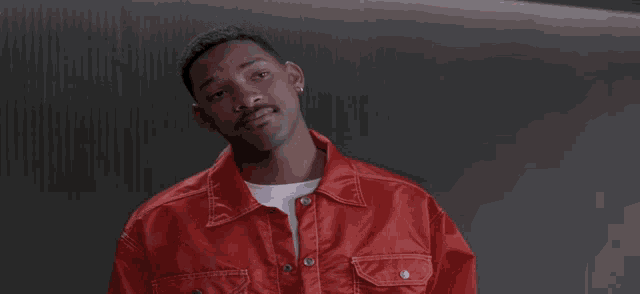 a man wearing a red jacket and a white shirt looks at the camera