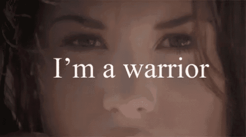 a close up of a woman 's face with the words " i 'm a warrior " in white letters