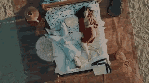 a man and a woman are laying in a bed on the beach .