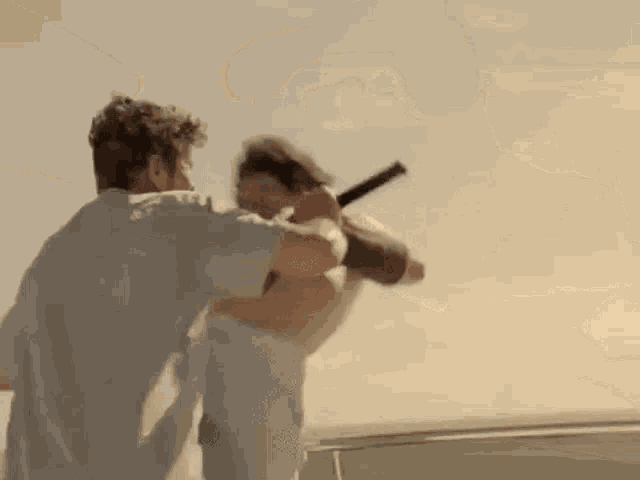 a man is holding another man 's hand while standing on a boat .