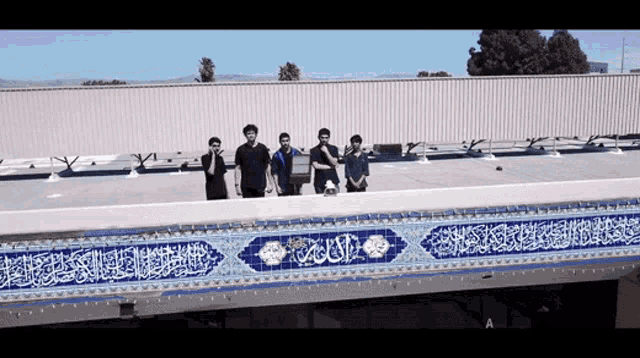 a group of young men standing on top of a building